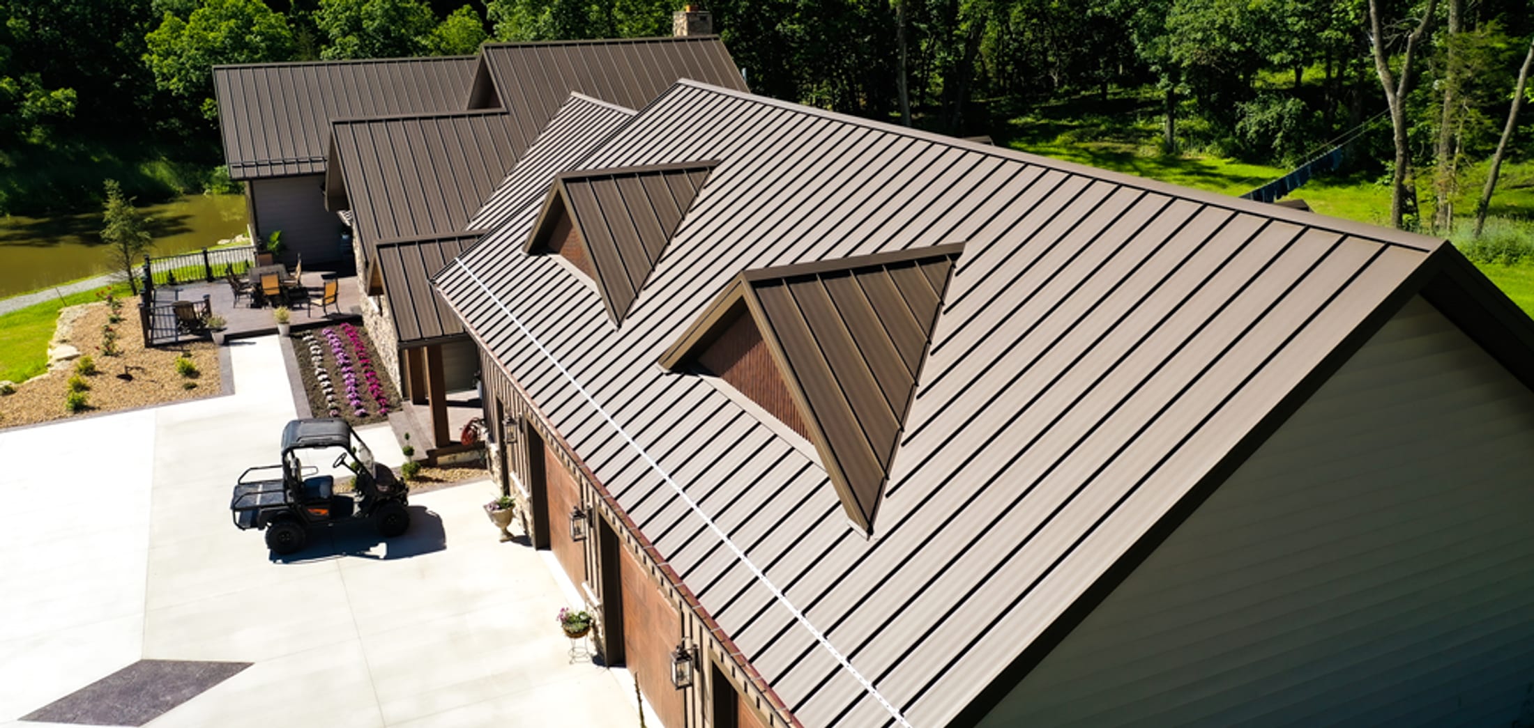 Aerial view of a Delta Metals standing-seam metal roof on a custom barndominium with multiple dormers